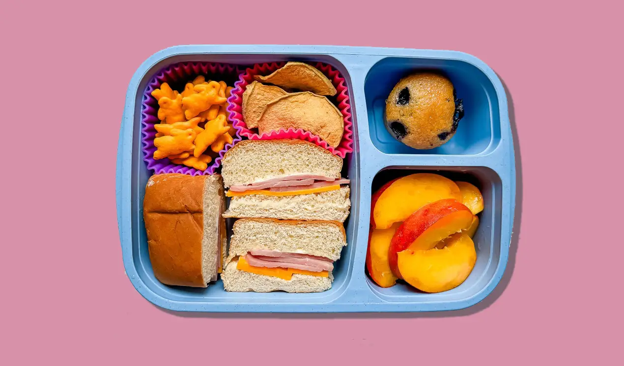 A lunch box with deli meat sandwich, Annie’s Bunnies, apple chips, a blueberry Abe’s Muffin and fresh peaches. A lunch box with deli meat sandwich, Annie’s Bunnies, apple chips, a blueberry Abe’s Muffin and fresh peaches.