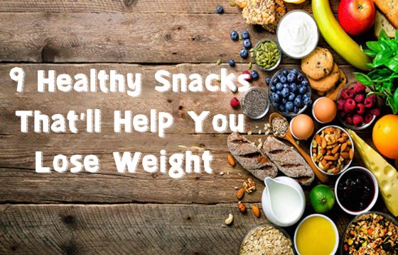 A variety of healthy snacks including fruits, nuts, eggs, yogurt, and whole grains on a wooden background with text saying "9 Healthy Snacks That'll Help You Lose Weight".