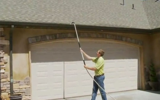 a man hold the gutter cleaning wand